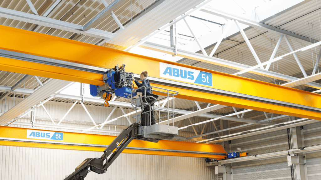 Teknisi memeriksa Load spectrum Recorder Hoist ABUS pada overhead crane dari platform kerja di dalam pabrik